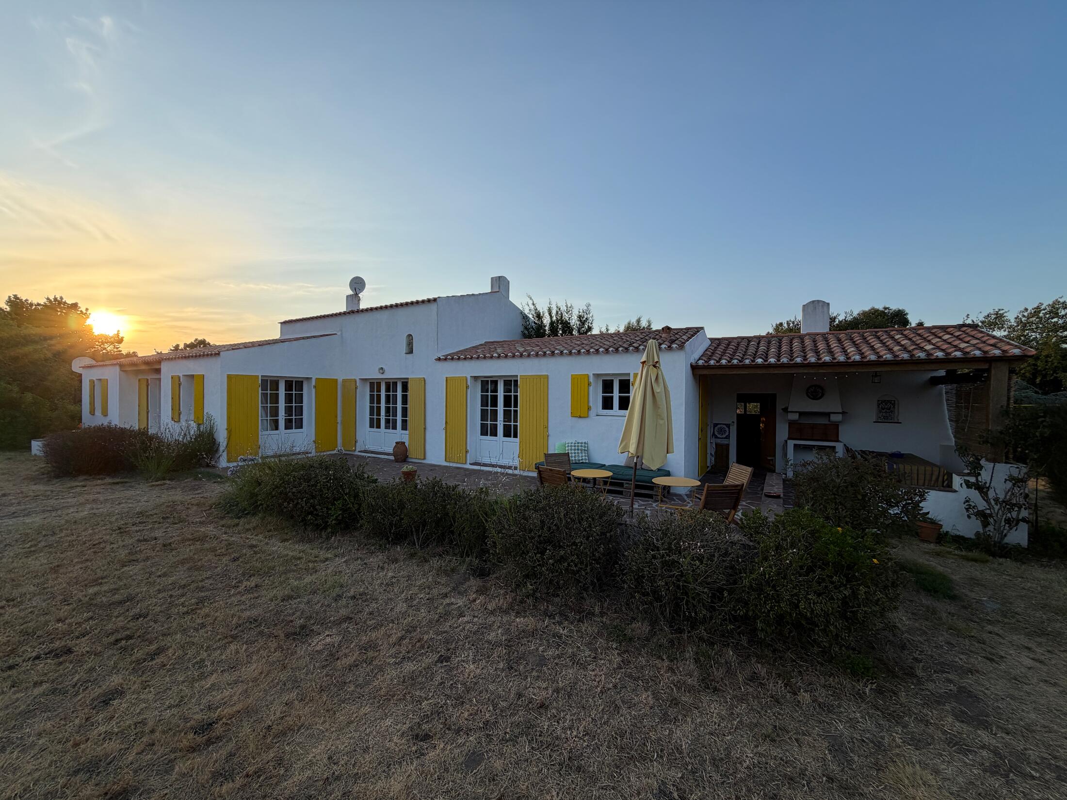 Haus mit Terrasse und Patio bei Sonnenuntergang