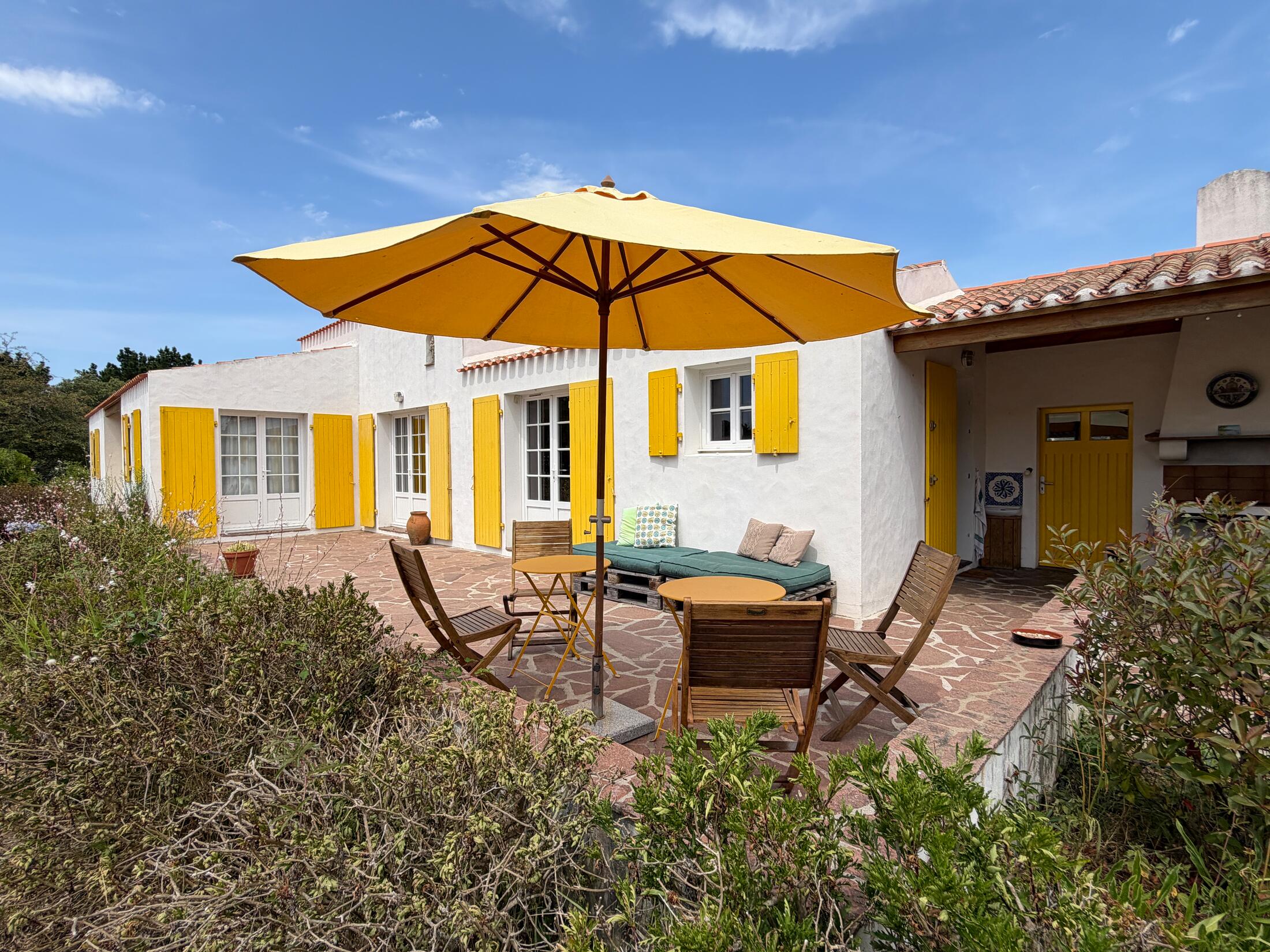 Terrasse mit Sonnenschirm, Sitzecke und Lounge-Bereich